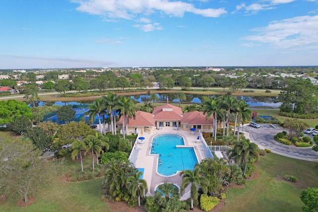 community pool with a patio area and a water view