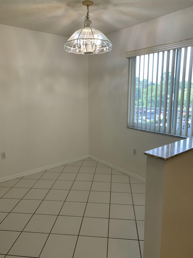 unfurnished room featuring tile patterned flooring and a textured ceiling