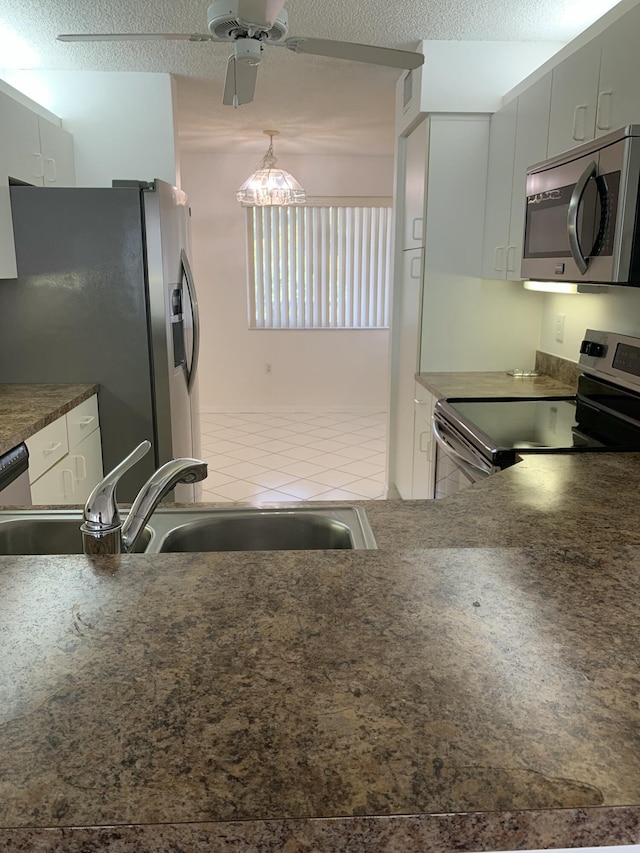 kitchen featuring pendant lighting, sink, gray cabinets, stainless steel appliances, and a textured ceiling