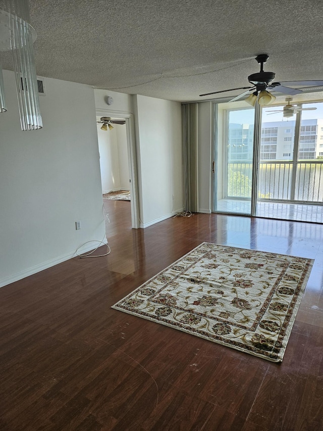 spare room with ceiling fan, dark hardwood / wood-style floors, and a textured ceiling