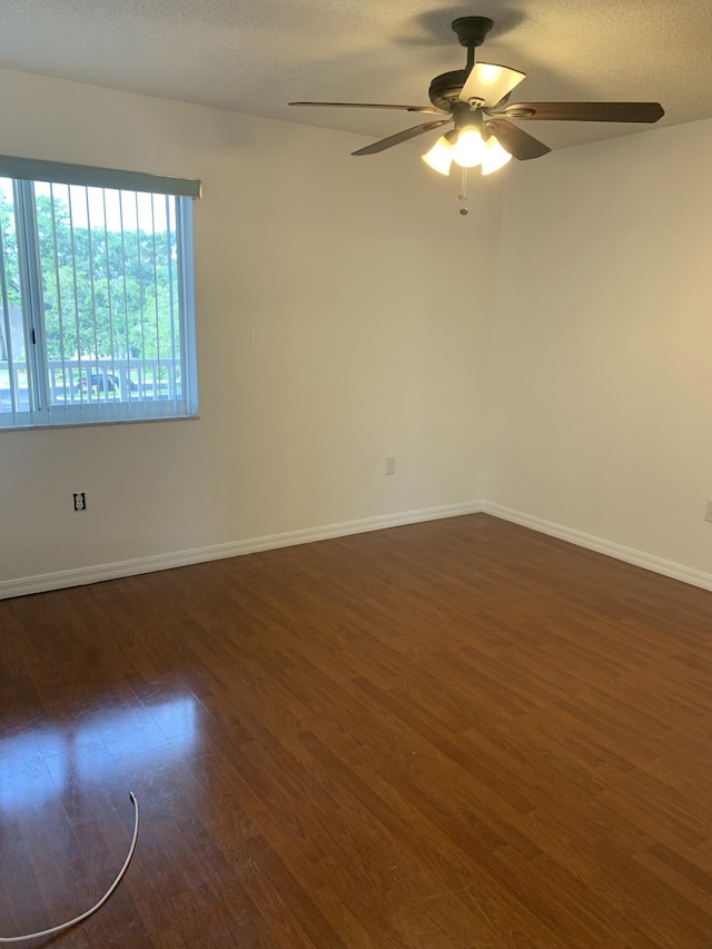 spare room with ceiling fan, dark hardwood / wood-style floors, and a textured ceiling