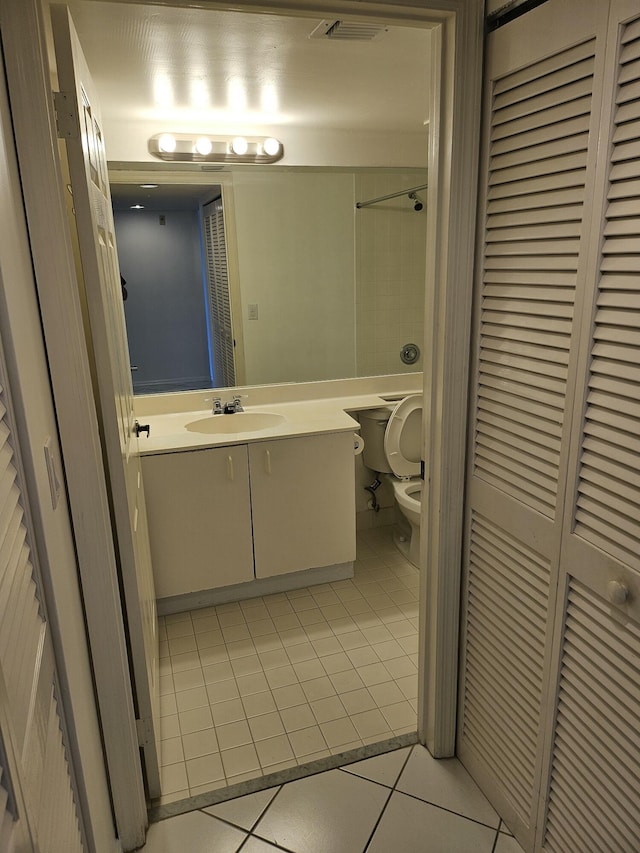 bathroom featuring vanity, a shower, tile patterned floors, and toilet