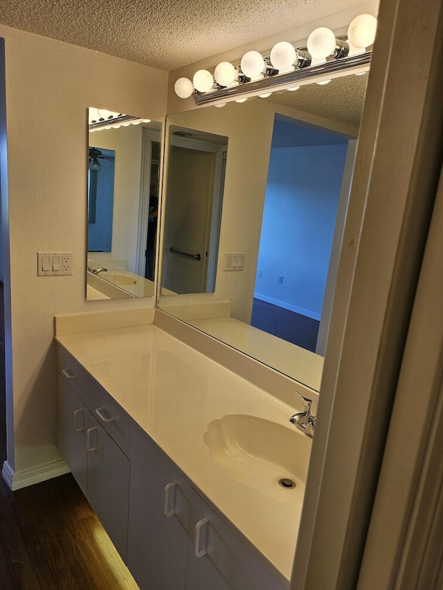 bathroom featuring vanity, hardwood / wood-style flooring, and a textured ceiling