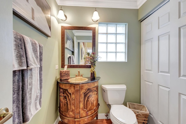 bathroom featuring crown molding, vanity, wood-type flooring, and toilet