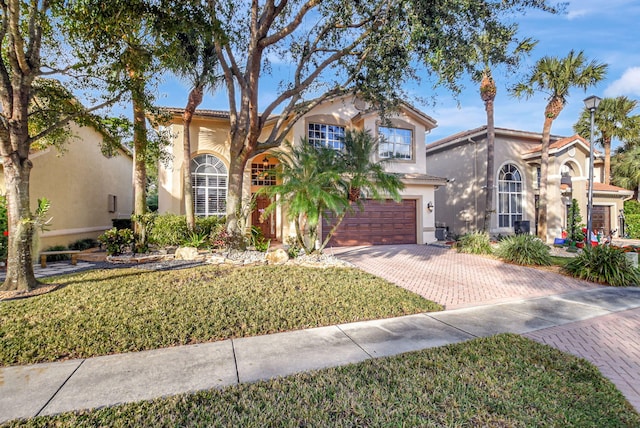 mediterranean / spanish-style house with a front yard and a garage