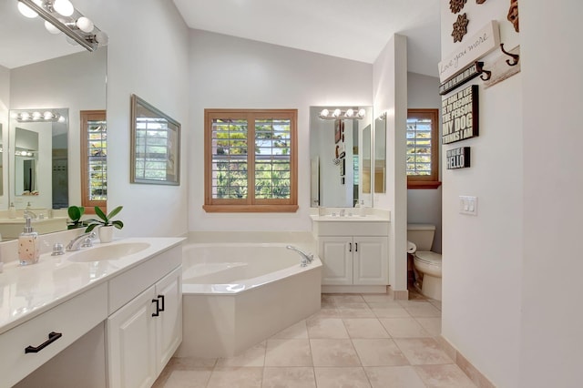 bathroom featuring tile patterned floors, vanity, a tub, and vaulted ceiling