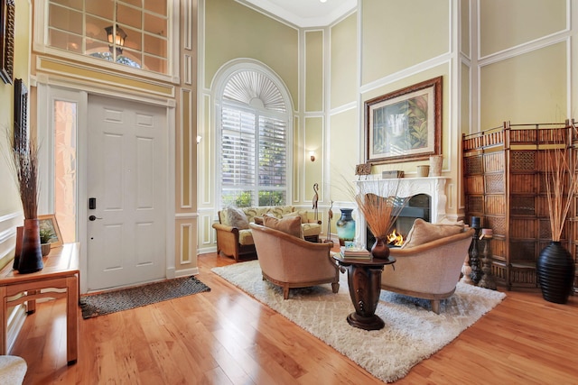 sitting room featuring hardwood / wood-style floors, ornamental molding, and a high ceiling