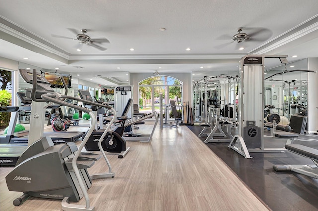 workout area featuring hardwood / wood-style floors, ceiling fan, ornamental molding, and a textured ceiling