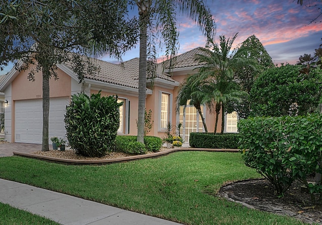 view of front of home with a lawn and a garage