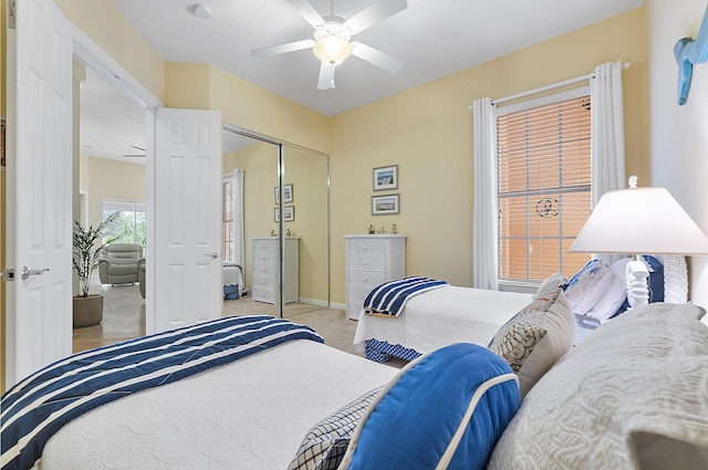 carpeted bedroom with ceiling fan and a closet