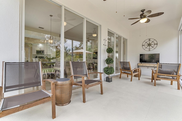 sunroom / solarium featuring ceiling fan