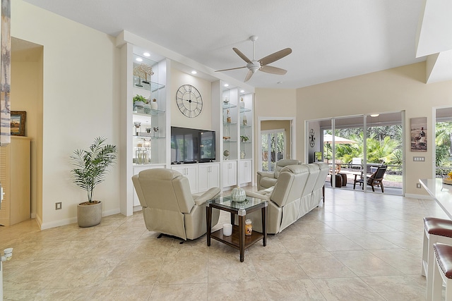 tiled living room with built in features and ceiling fan