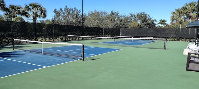 view of tennis court featuring basketball hoop