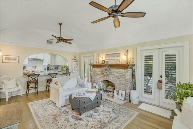 living room with brick ceiling, ceiling fan, french doors, and vaulted ceiling