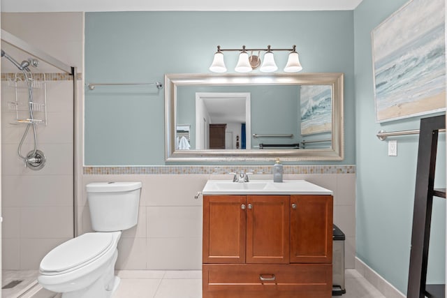 bathroom with tile patterned floors, vanity, toilet, and tile walls