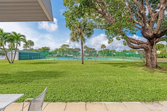 exterior space with a lawn and tennis court