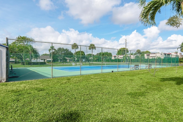 view of tennis court with a yard