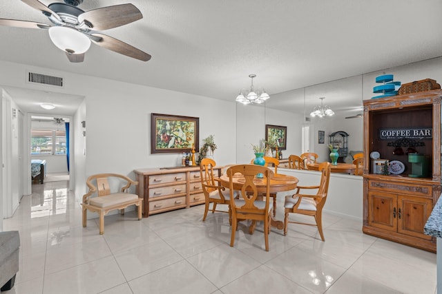 dining room with a textured ceiling, ceiling fan with notable chandelier, and light tile patterned flooring