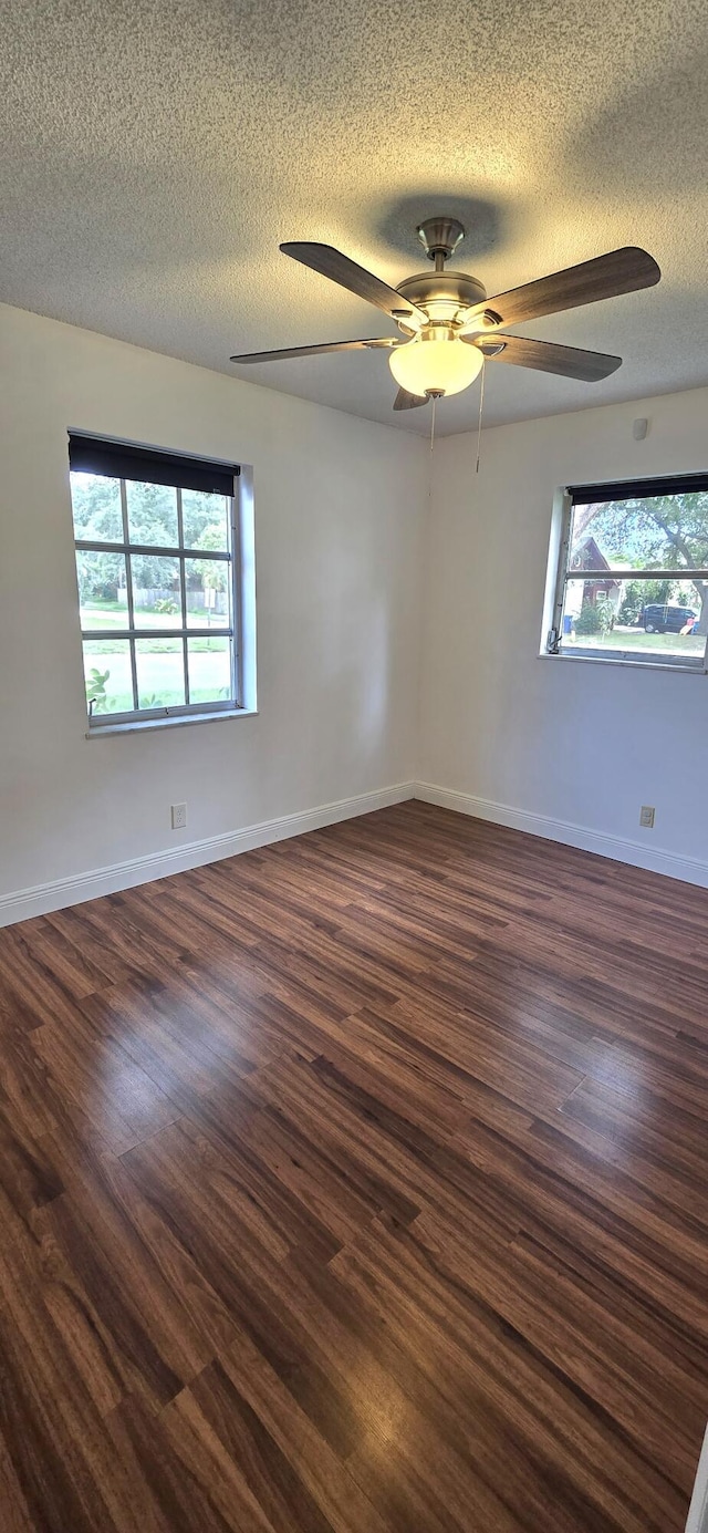 spare room with ceiling fan, dark wood-type flooring, and a textured ceiling