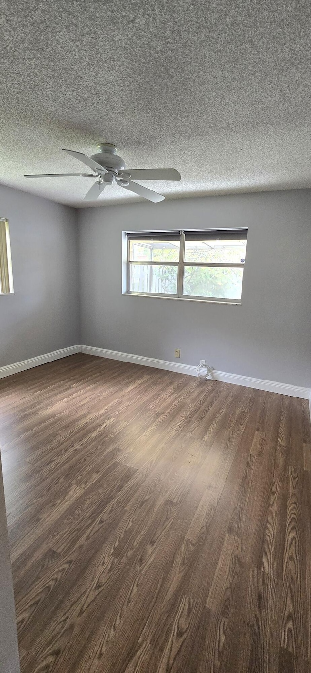 unfurnished room featuring dark hardwood / wood-style flooring and a textured ceiling