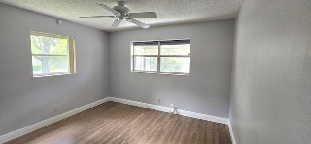 empty room featuring ceiling fan, a healthy amount of sunlight, a textured ceiling, and wood-type flooring