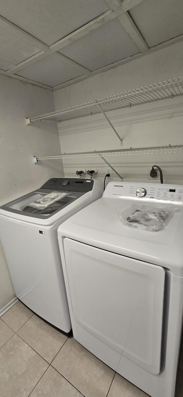 washroom with washer and dryer and light tile patterned floors