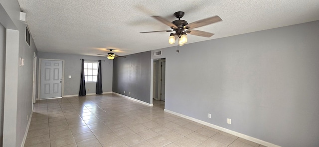 tiled spare room featuring ceiling fan and a textured ceiling