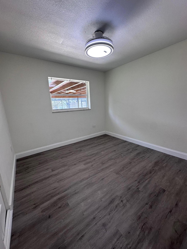 unfurnished room featuring a textured ceiling and dark wood-type flooring