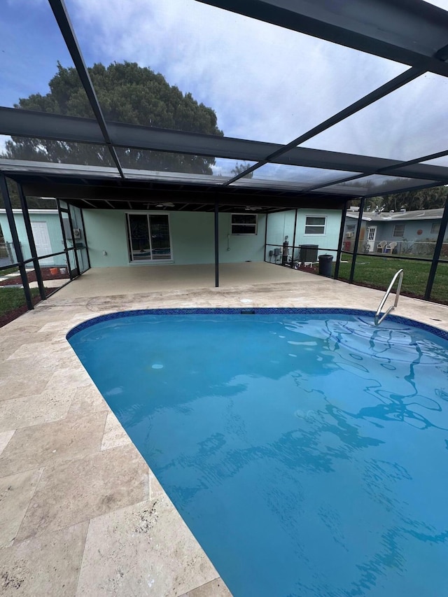 view of swimming pool featuring glass enclosure and a patio