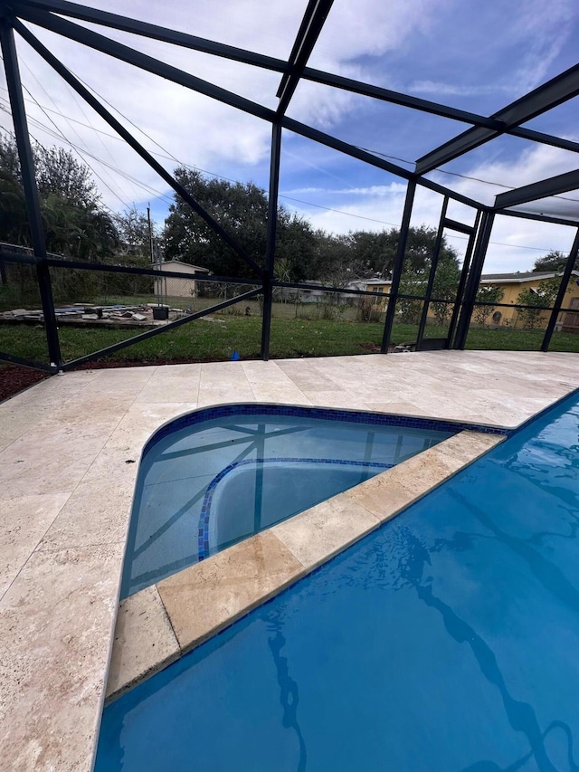 view of swimming pool with a patio area and a lanai