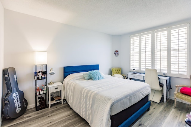 bedroom featuring a textured ceiling and hardwood / wood-style flooring