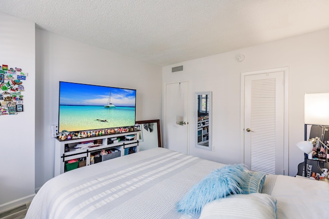 bedroom featuring hardwood / wood-style floors and a textured ceiling