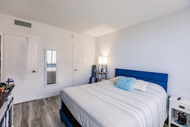 bedroom featuring hardwood / wood-style floors and a textured ceiling