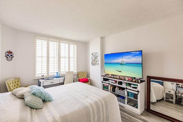 bedroom with a textured ceiling and light wood-type flooring