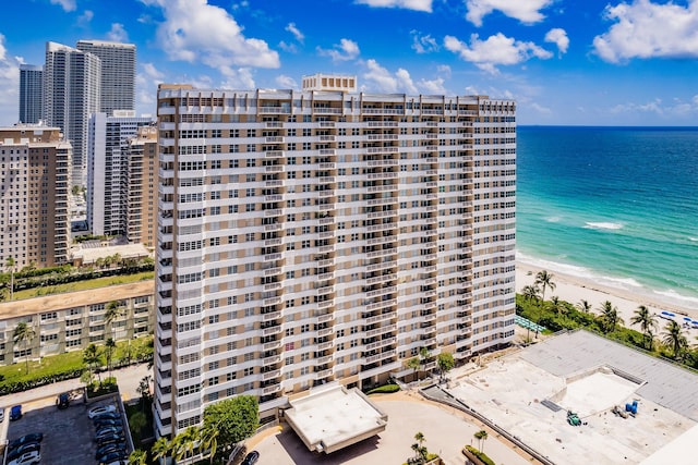 view of building exterior featuring a water view and a beach view