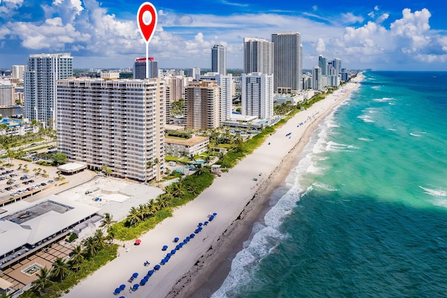 birds eye view of property featuring a water view and a beach view