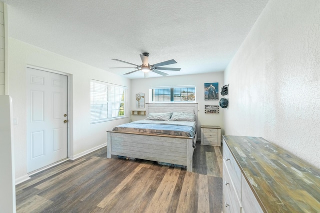 bedroom featuring ceiling fan, dark hardwood / wood-style flooring, and a textured ceiling