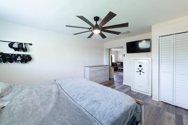 bedroom featuring a closet, ceiling fan, dark hardwood / wood-style flooring, and a textured ceiling