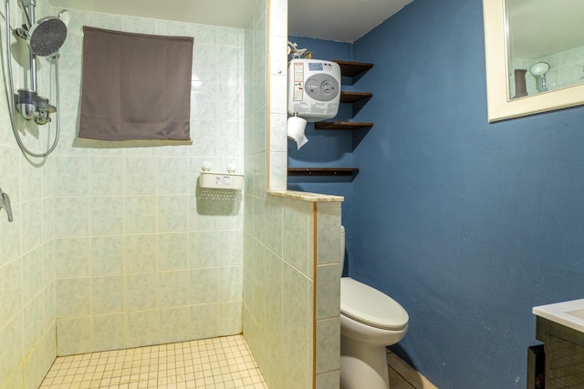 bathroom with a tile shower and toilet