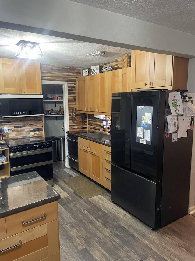 kitchen featuring black refrigerator, electric stove, dark wood-type flooring, and light brown cabinetry