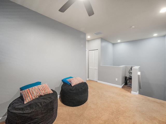 sitting room featuring ceiling fan and light carpet