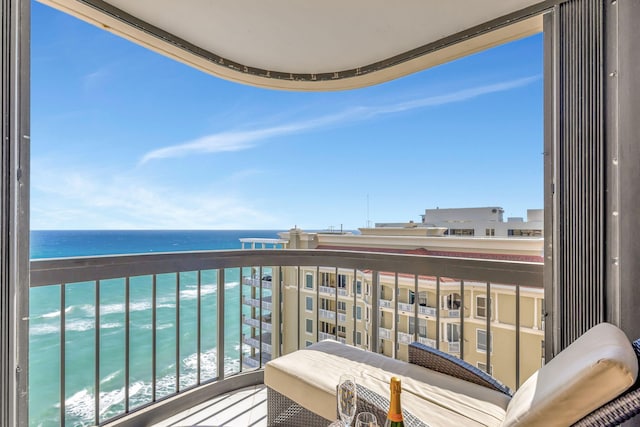 balcony with a water view and a view of the beach