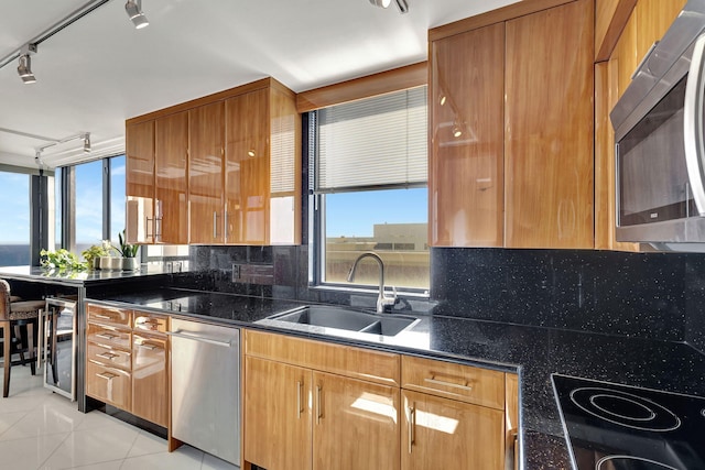 kitchen with decorative backsplash, light tile patterned flooring, sink, and appliances with stainless steel finishes