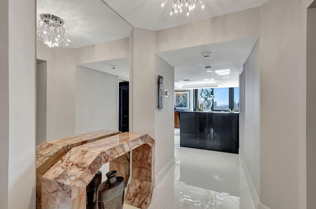 corridor with a chandelier and light tile patterned floors