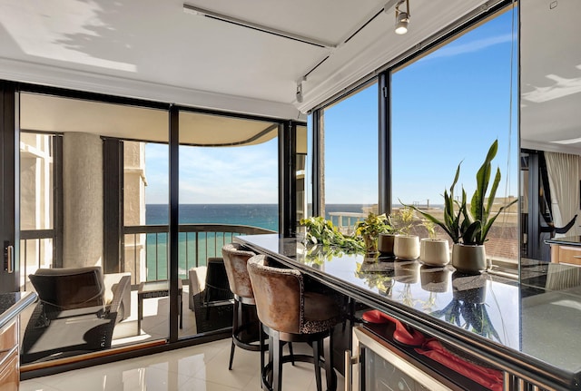 sunroom / solarium featuring a water view