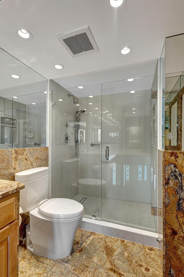 bathroom with vanity, toilet, and a shower with shower door