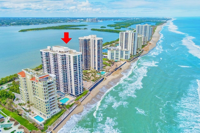 birds eye view of property featuring a beach view and a water view