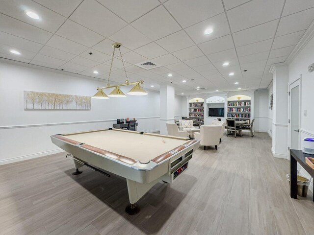 recreation room featuring light wood-type flooring, built in features, ornamental molding, and billiards