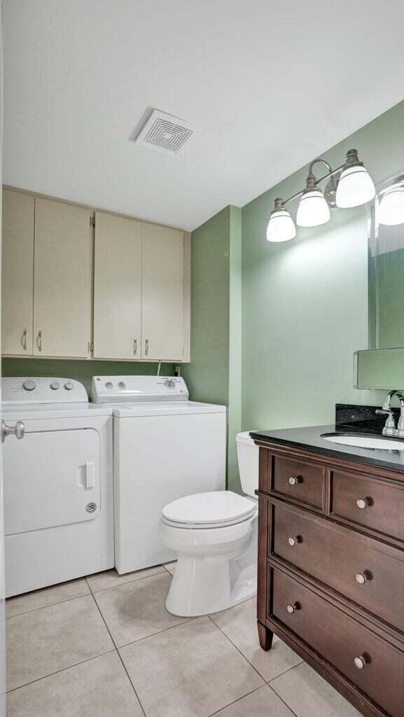 bathroom with tile patterned flooring, toilet, vanity, and independent washer and dryer