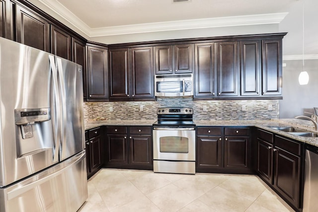 kitchen featuring light stone counters, tasteful backsplash, appliances with stainless steel finishes, and a sink